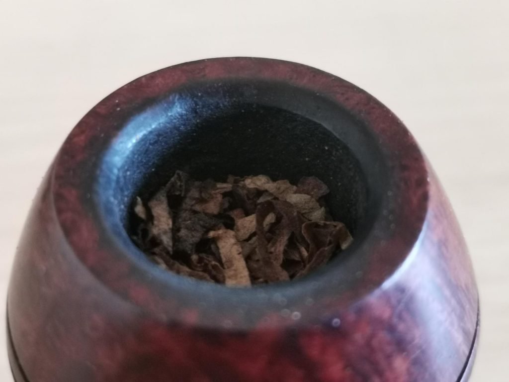 Pfeifenkopf halb gefüllt mit Tabak